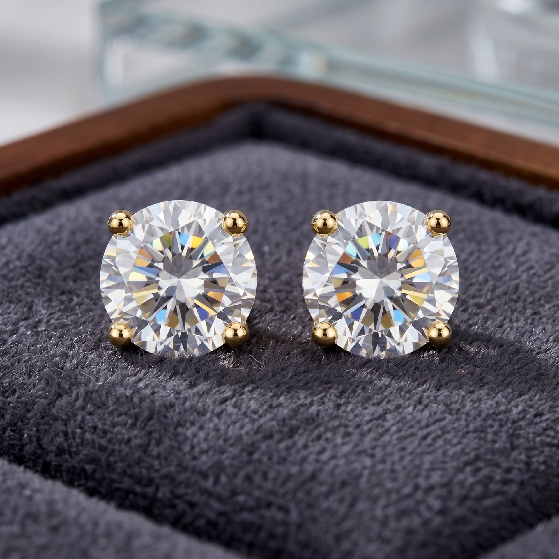 Pair of diamond stud earrings on a textured surface