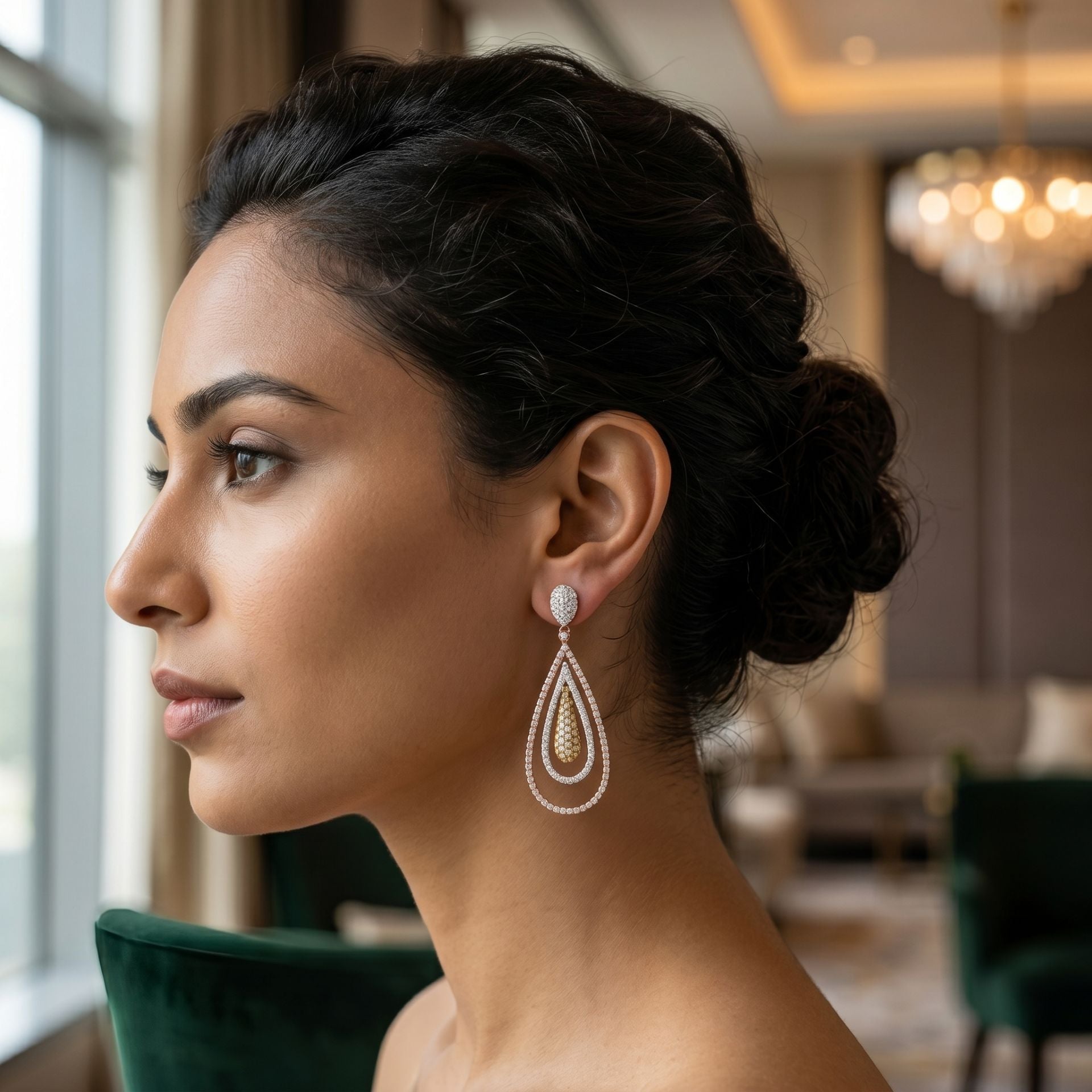 Woman wearing elegant teardrop dangle earrings featuring sparkling lab-grown diamonds in a luxury indoor setting.