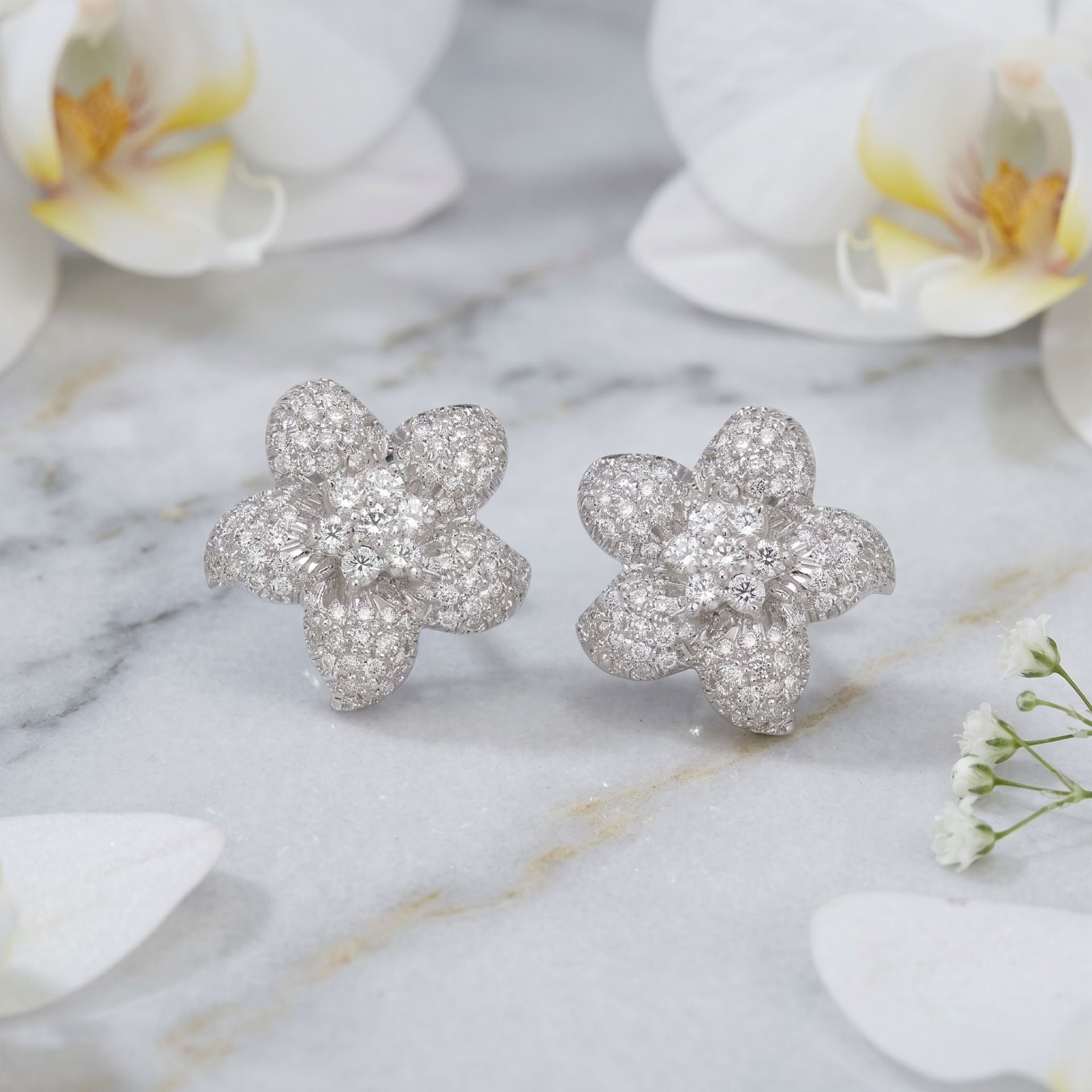 Floral lab grown diamond stud earrings on a marble background