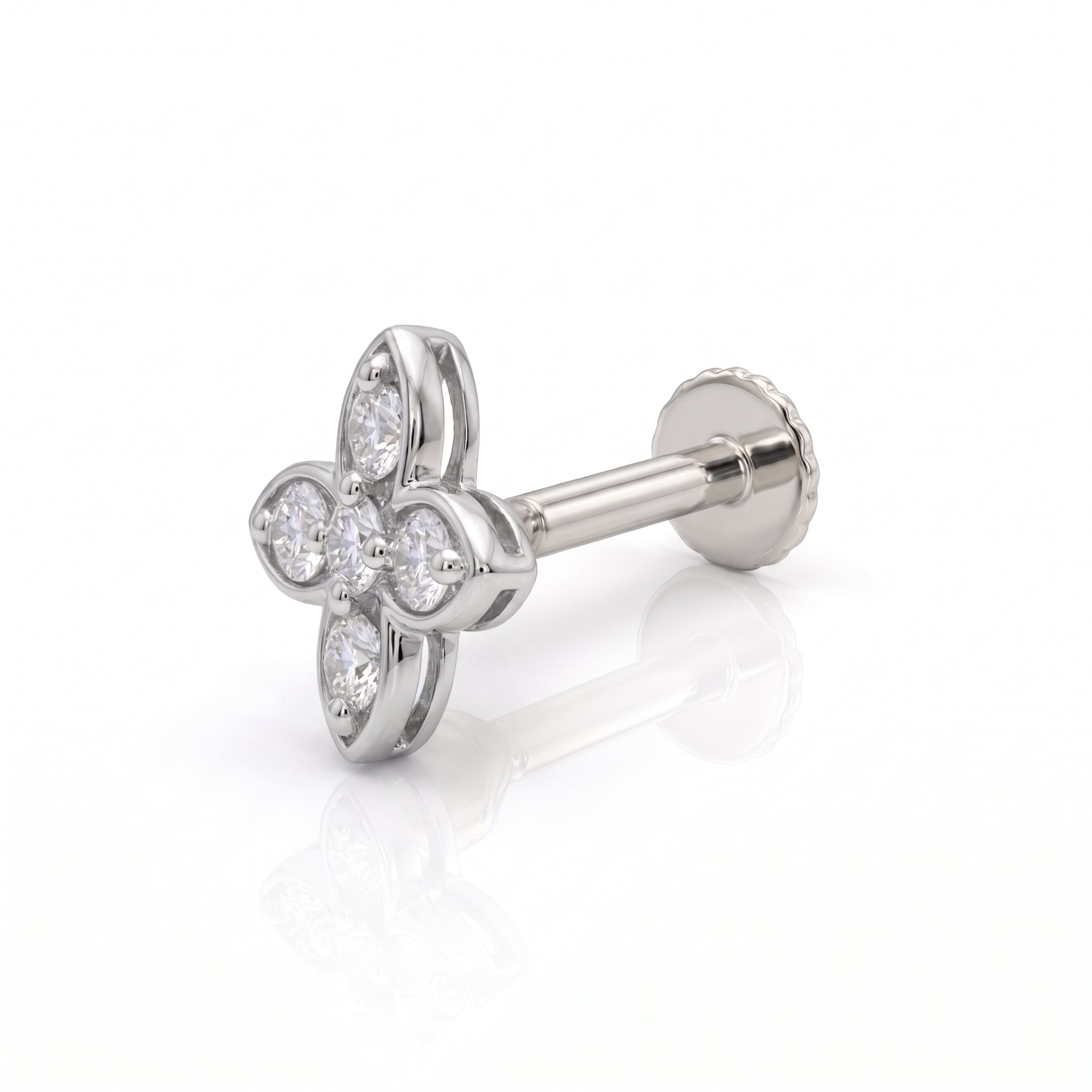 A silver-toned four-petal flower stud nose ring with clear gemstones, shown from an angled side view on a white reflective background.