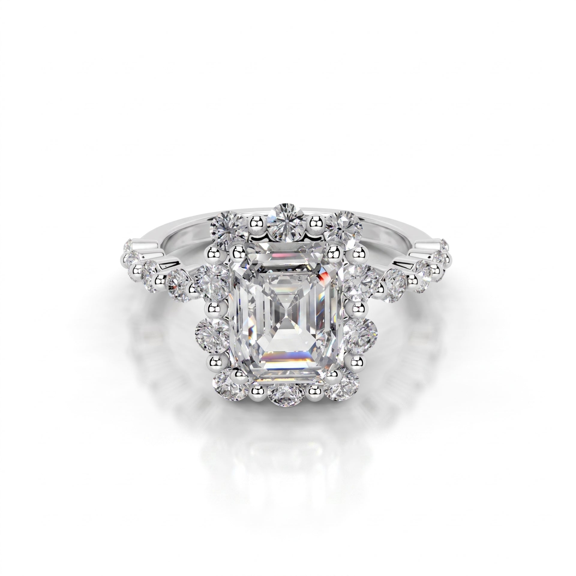 Diamond ring with a central emerald-cut gemstone on a white background