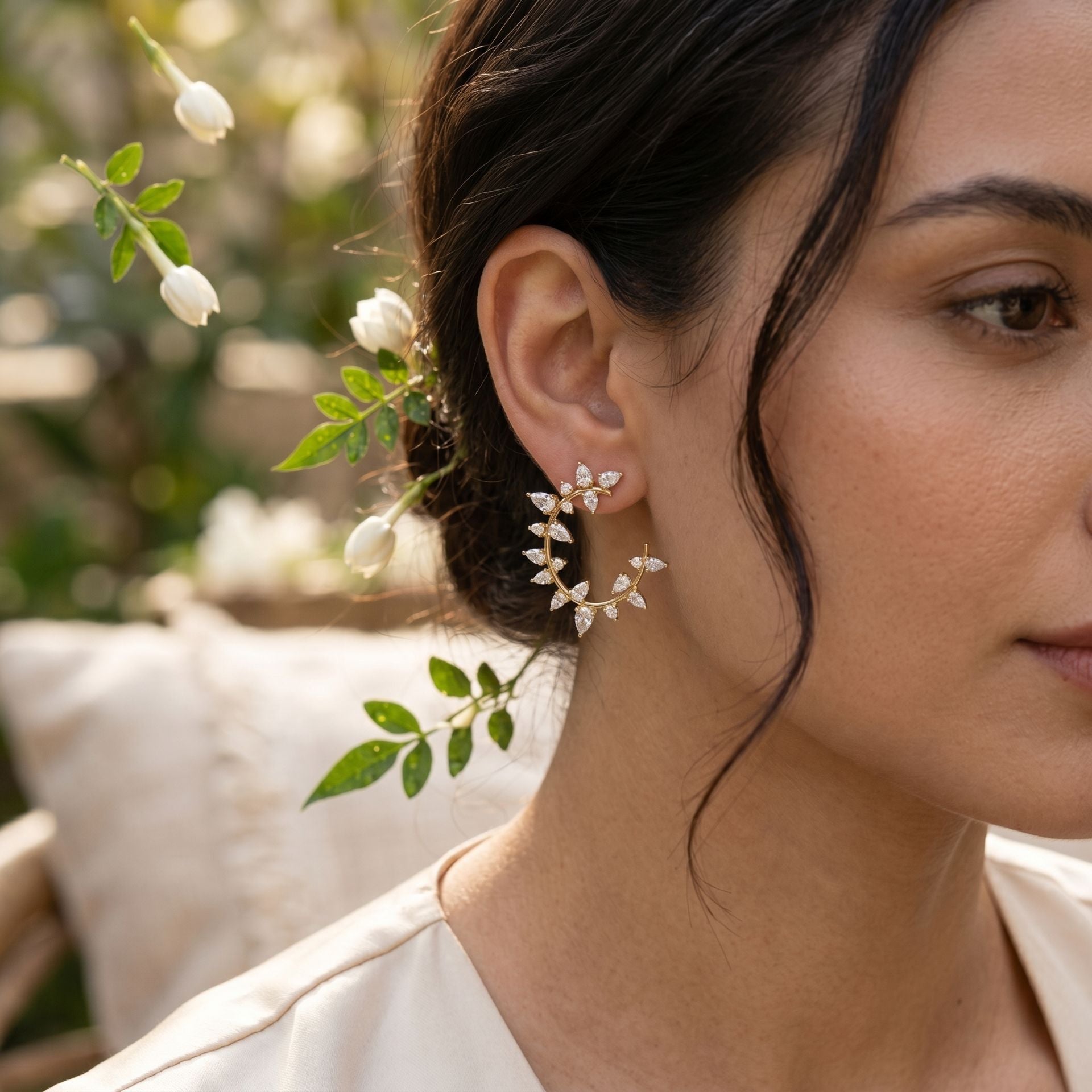 Close-up of a woman wearing floral earrings with a blurred natural background