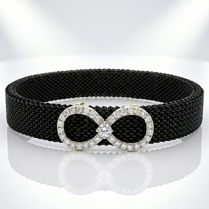 Black belt with a silver infinity symbol buckle on a reflective surface.