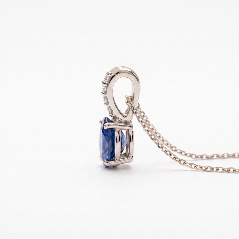 A silver pendant necklace featuring a rectangular blue gemstone in a prong setting, suspended from a delicate silver chain against a plain white background.