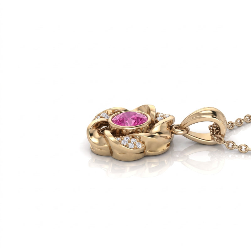 A yellow gold pendant necklace featuring a central oval pink gemstone surrounded by small clear accent stones, shown on a clean white background with a soft reflection.