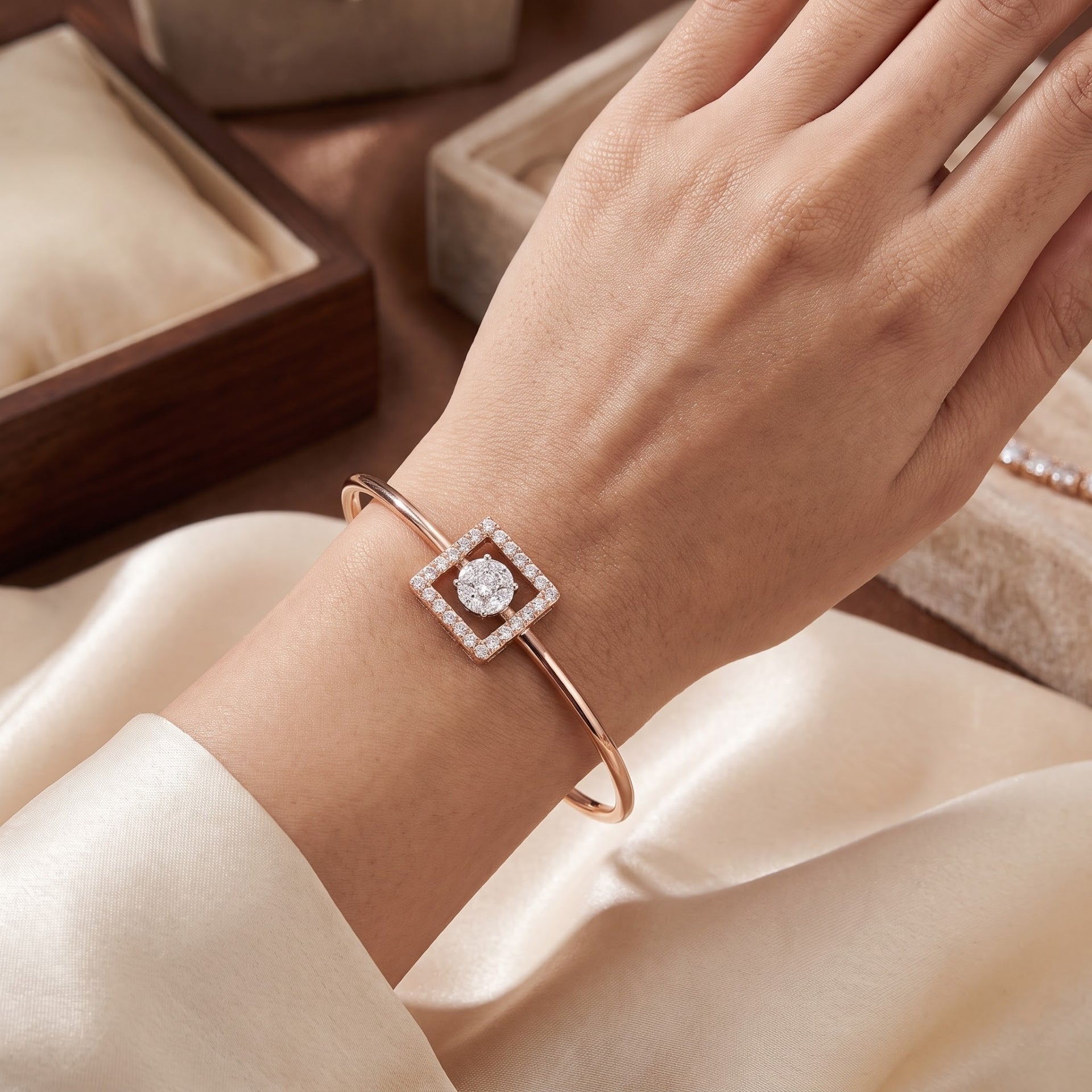 A rose gold bangle bracelet with a square diamond setting worn on a woman&