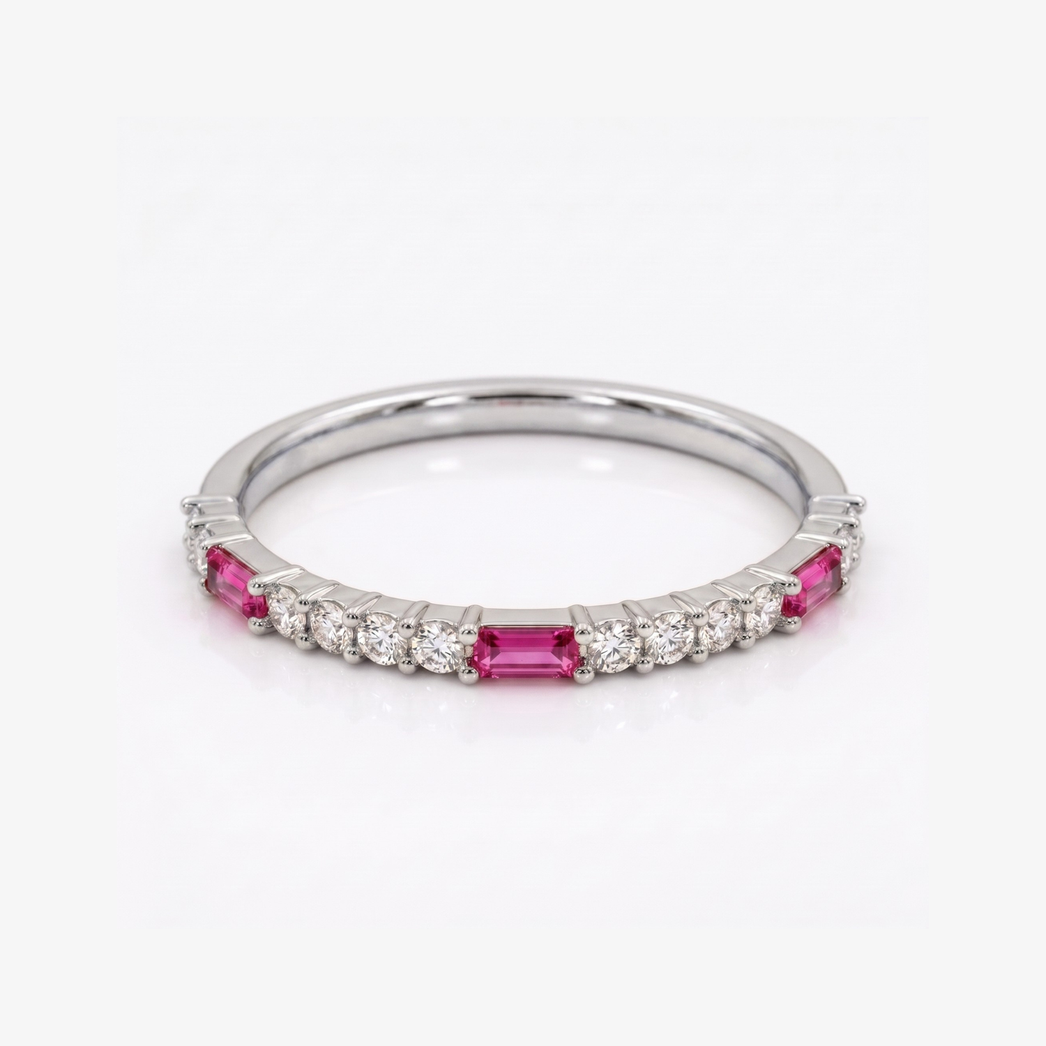 A silver band ring featuring rectangular pink gemstones and small round clear stones, photographed on a clean white background.