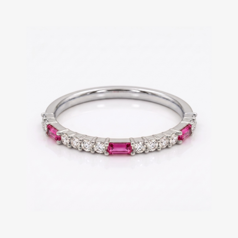 A silver band ring featuring rectangular pink gemstones and small round clear stones, photographed on a clean white background.