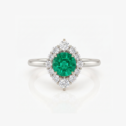 A silver ring featuring a round green emerald-cut center stone surrounded by a halo of round clear stones, set on a polished silver band against a white background.
