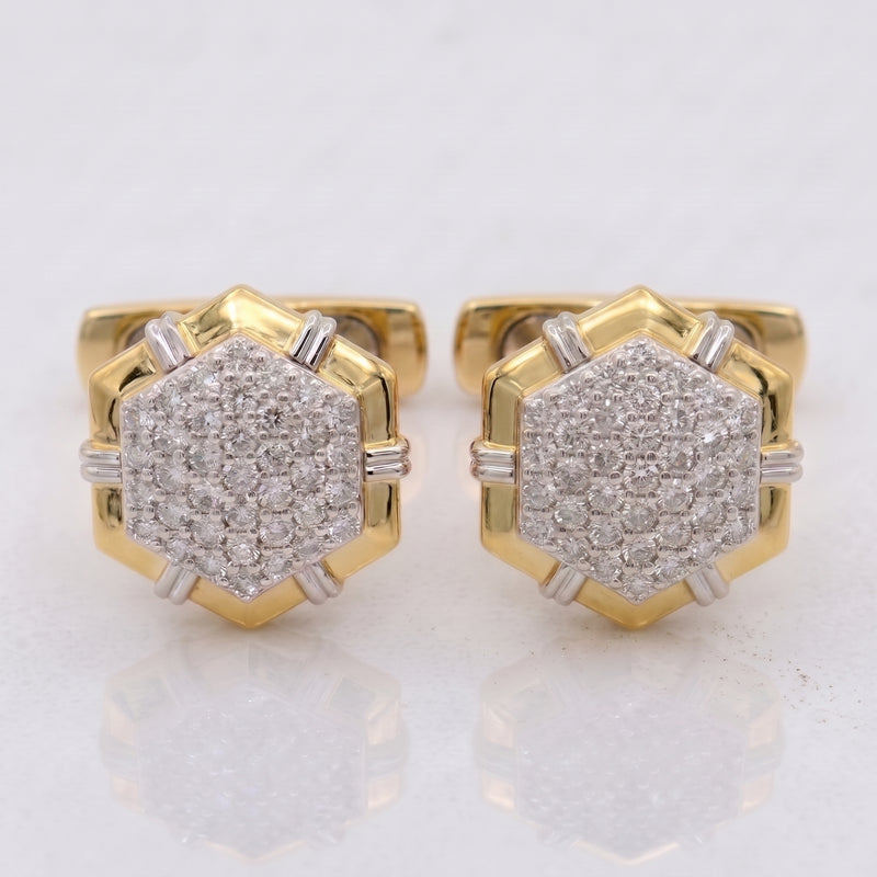 A pair of gold hexagonal stud earrings with pavé-set clear gemstones and small silver-toned side accents, shown on a light reflective surface.