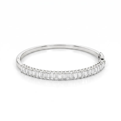 A slim silver bangle bracelet featuring a continuous row of baguette-cut clear stones along the front band, set against a clean white background.