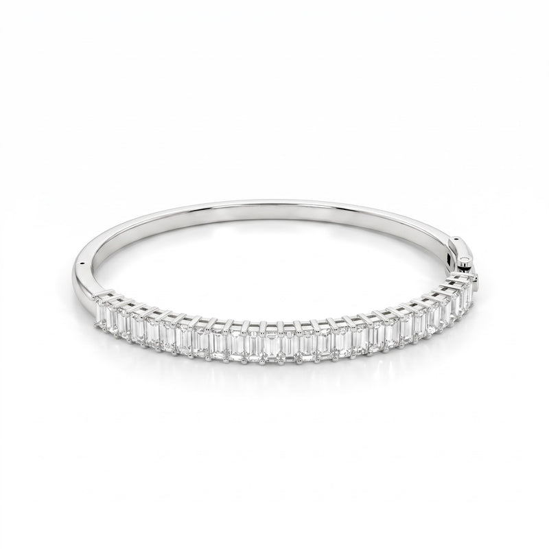 A slim silver bangle bracelet featuring a continuous row of baguette-cut clear stones along the front band, set against a clean white background.