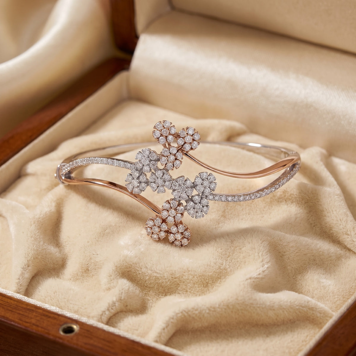 A rose gold cuff bracelet with diamond floral accents, displayed inside an open cream satin jewelry box.