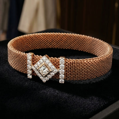 Rose gold mesh bracelet with geometric diamond detail on a dark background