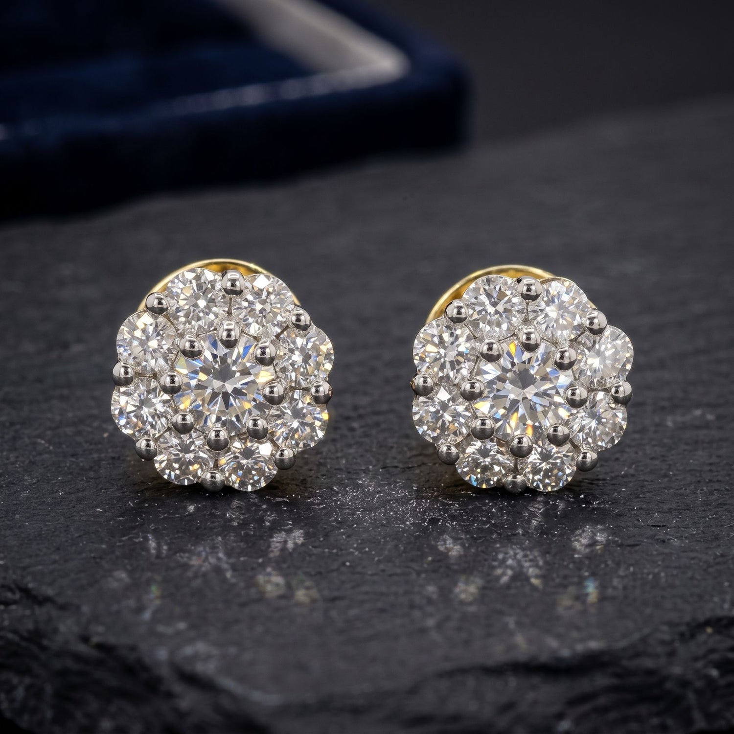 Pair of diamond earrings on a dark surface