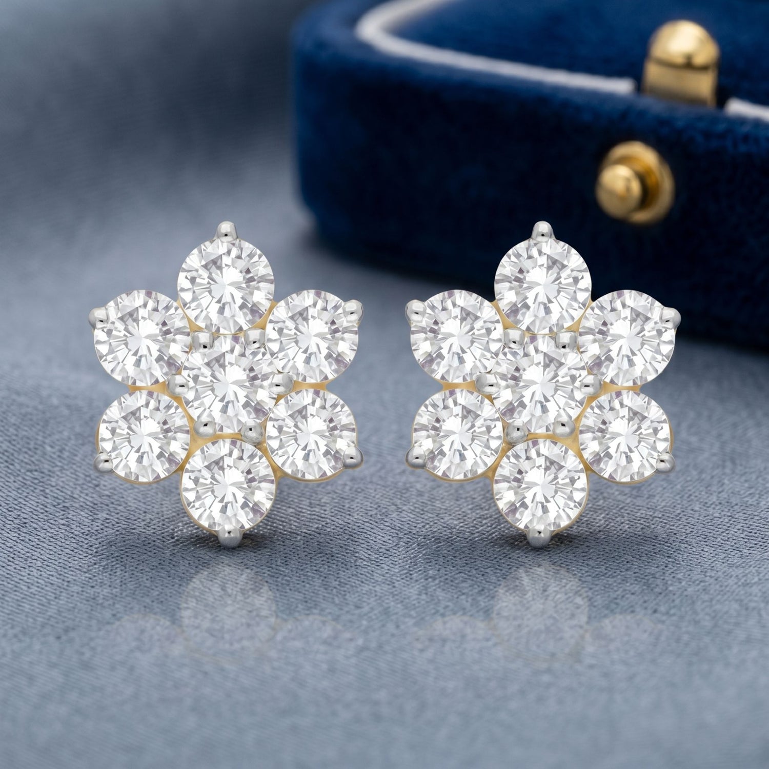 Snowflake-inspired lab grown diamond stud earrings on a grey background