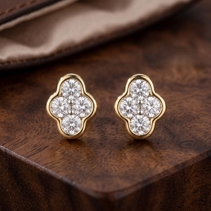 Gold and diamond earrings on a wooden surface