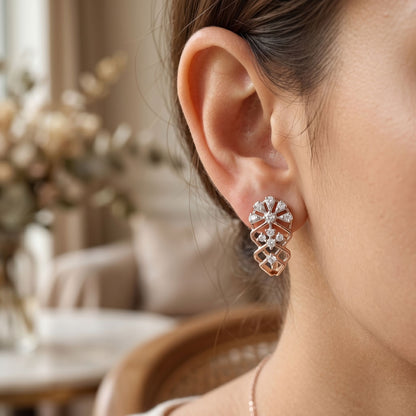 Close-up of a person wearing a diamond earring with a blurred indoor background