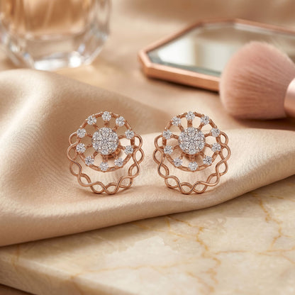 Rose gold earrings with diamond accents on a beige fabric surface