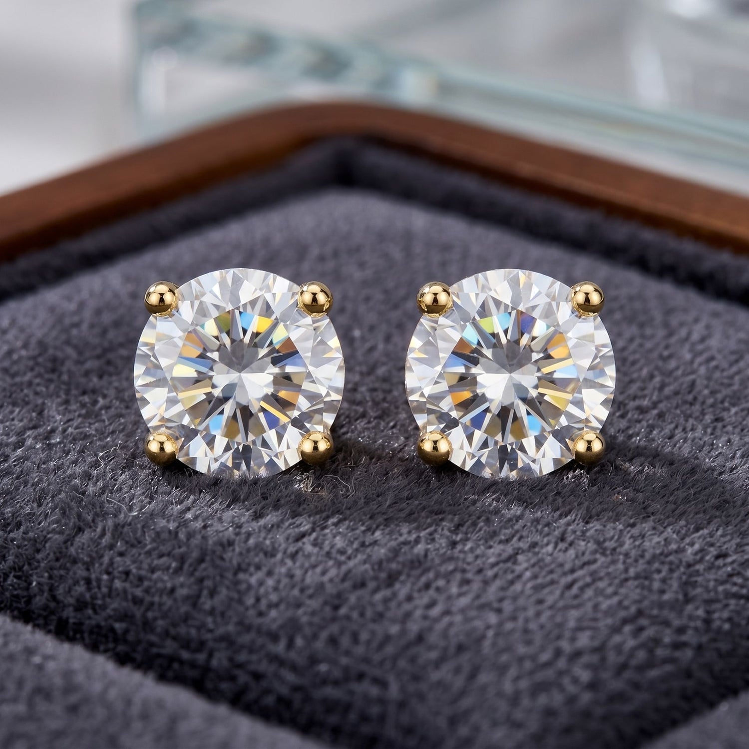 Pair of diamond stud earrings on a textured surface