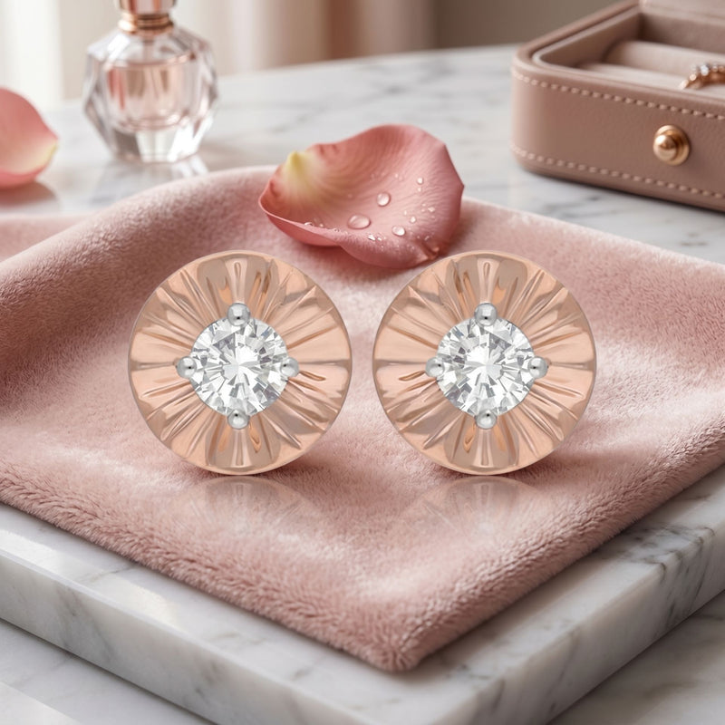 Rose gold earrings with diamonds on a pink cloth