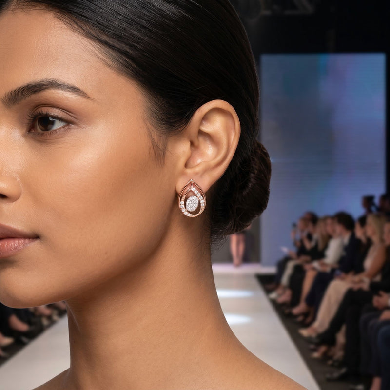 Woman wearing earrings at a fashion show with an audience in the background