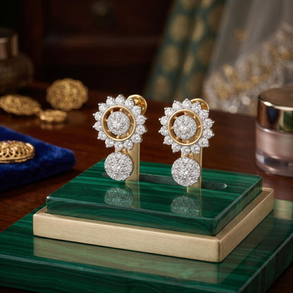 Pair of gold and diamond earrings on a green stand with a blurred background
