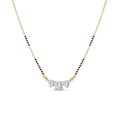 A delicate gold chain necklace with a black bead line and a central cluster of clear gemstones, shown on a plain white background.