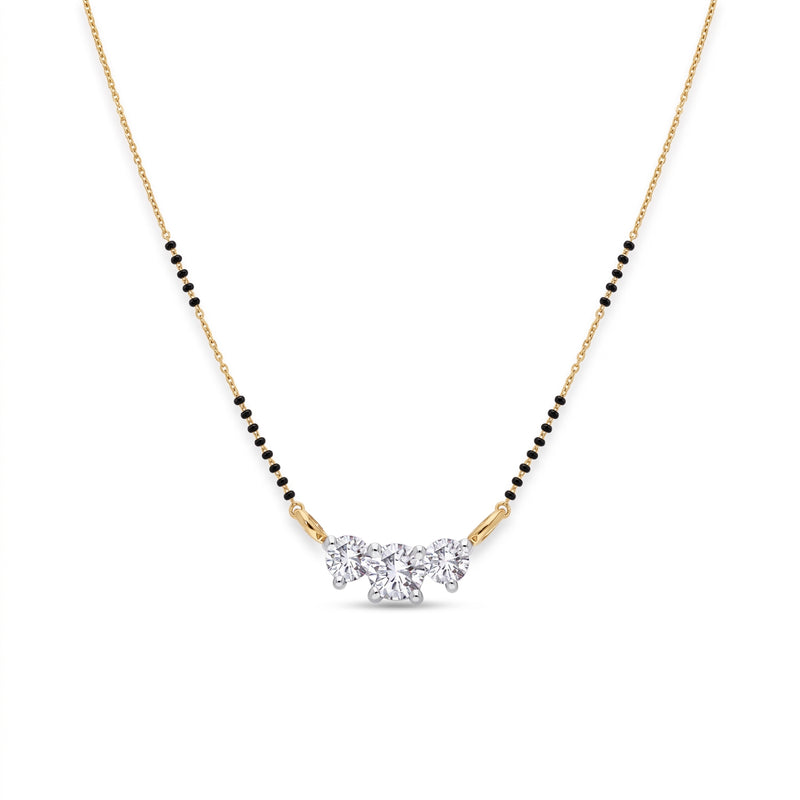 A delicate gold chain necklace with a black bead line and a central cluster of clear gemstones, shown on a plain white background.