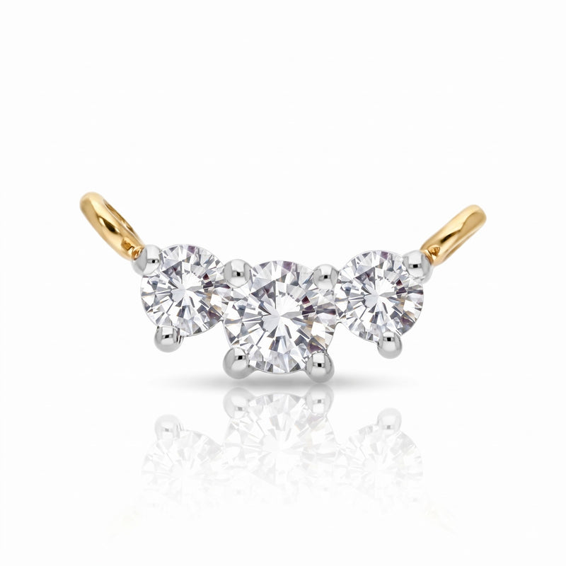 A three-stone diamond engagement ring featuring a central round brilliant-cut diamond flanked by two smaller round diamonds, set in a yellow gold and white gold or platinum bridge with curved gold posts.