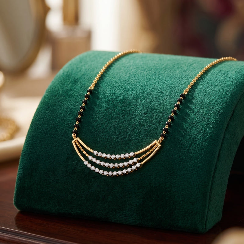 A gold necklace with three curved rows of white pearls and small black beads, displayed on a green velvet jewelry stand.