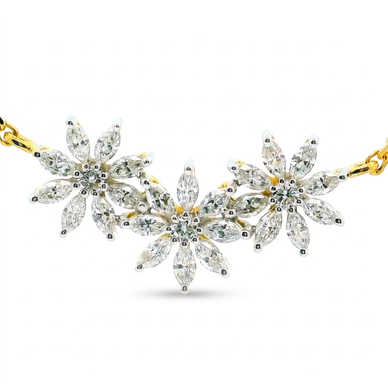 A gold and silver floral necklace featuring marquise-cut clear gemstones in a daisy chain pattern, displayed on a clean white background.