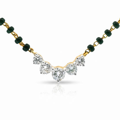 A delicate necklace featuring a central cluster of five clear heart-shaped gemstones in a gold setting, suspended from a chain accented with dark green beads on both sides, set against a clean white background.