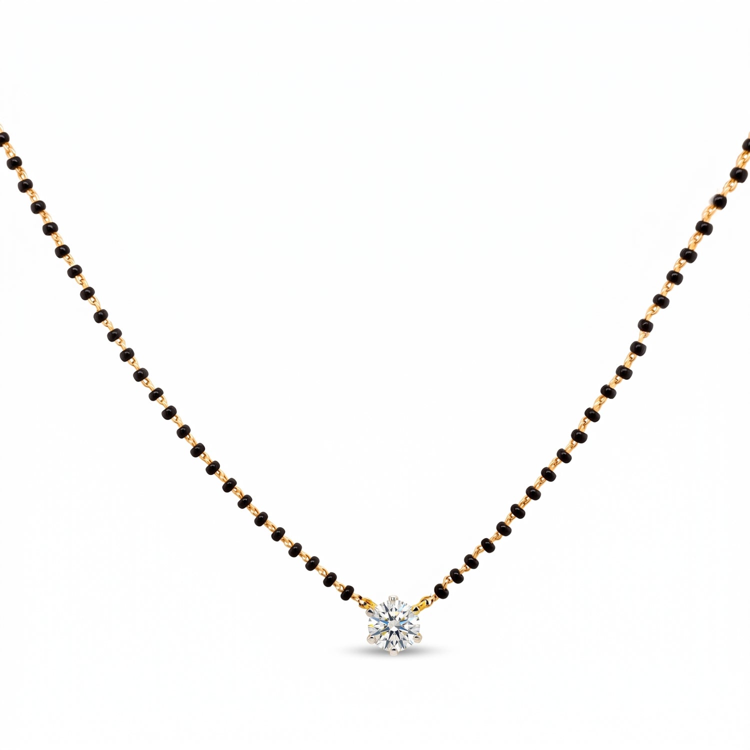 A delicate black and gold beaded necklace with a small, clear, multi-stone starburst pendant, displayed on a solid white background.