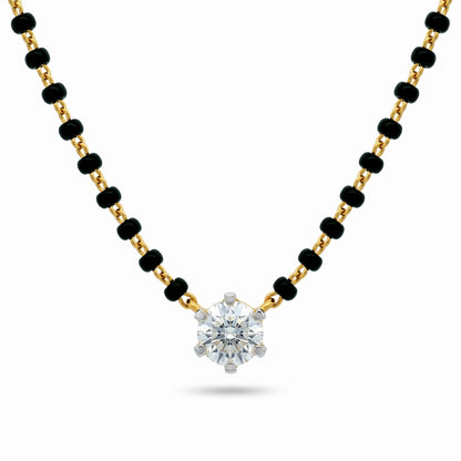 A gold and black beaded necklace with a single round-cut clear gemstone pendant, displayed on a clean white background.