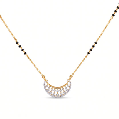 A gold chain necklace featuring a crescent-shaped pendant adorned with small clear stones and black bead accents along the chain, shown on a plain white background.
