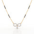 A gold chain necklace featuring a central infinity symbol pendant paved with clear stones and a dangling clear teardrop stone, with small black bead accents along the chain, shown on a white background.