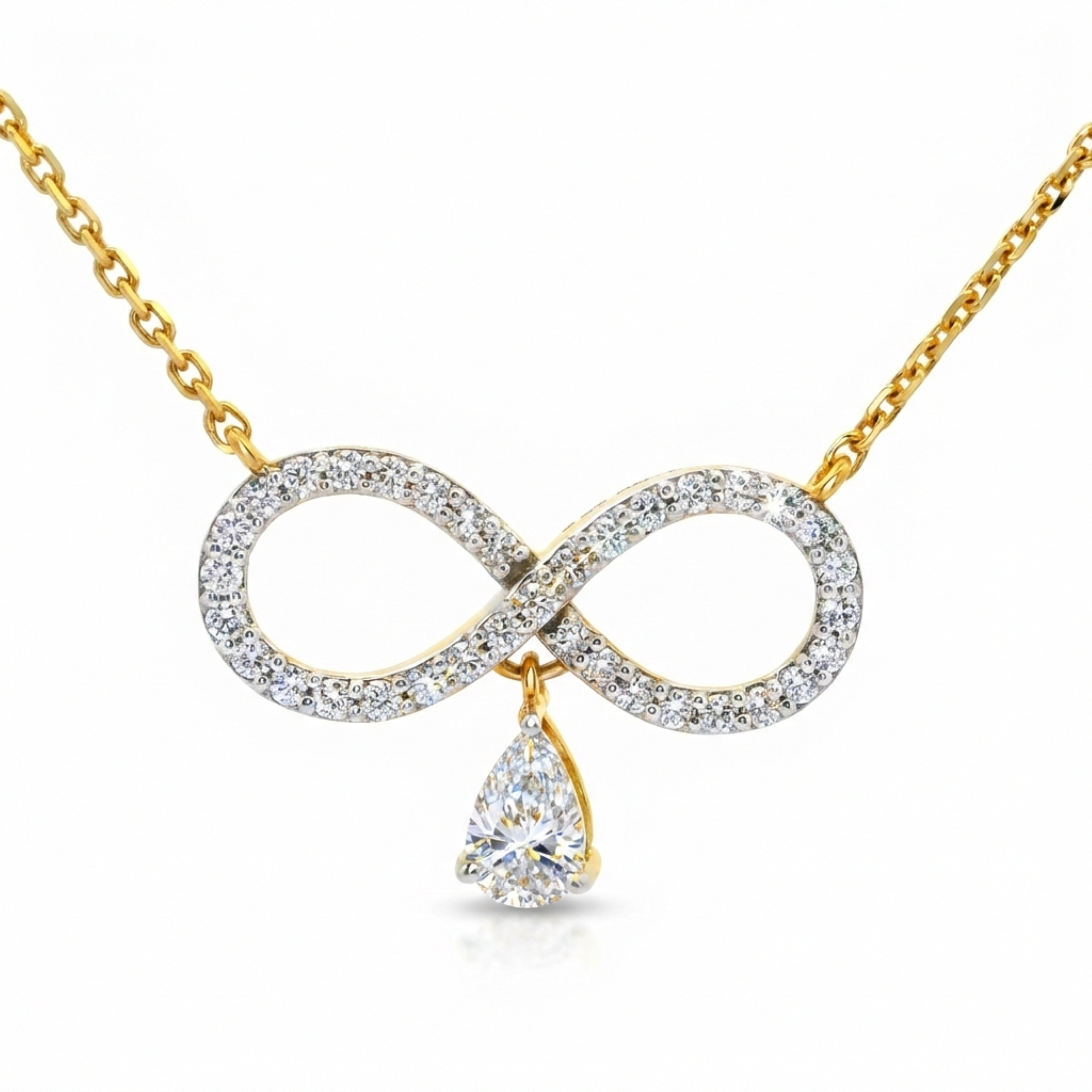 A gold necklace featuring an infinity symbol pendant paved with clear stones, with a teardrop-shaped clear gemstone hanging from the center, shown on a white background.