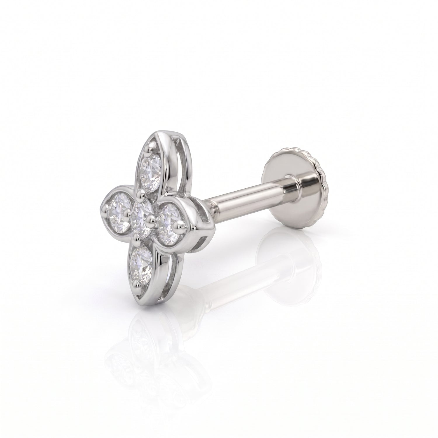 A silver-toned four-petal flower stud nose ring with clear gemstones, shown from an angled side view on a white reflective background.
