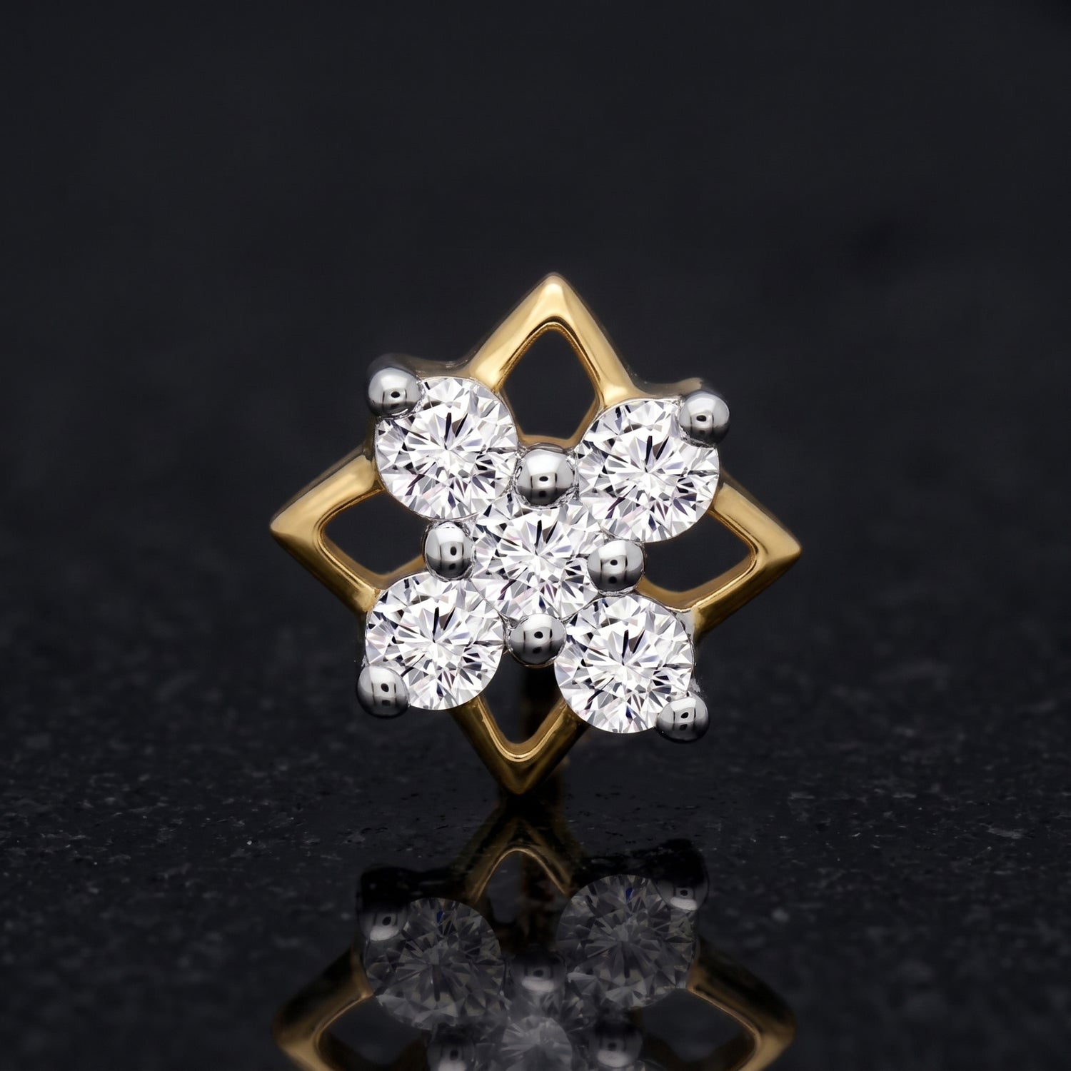 A gold and silver-tone diamond cluster stud nosepin featuring a six-petal floral design with round-cut clear stones, set against a dark reflective background.