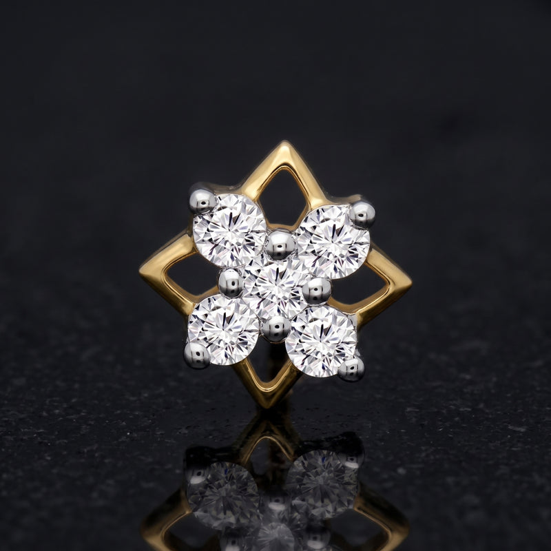 A gold and silver-tone diamond cluster stud nosepin featuring a six-petal floral design with round-cut clear stones, set against a dark reflective background.