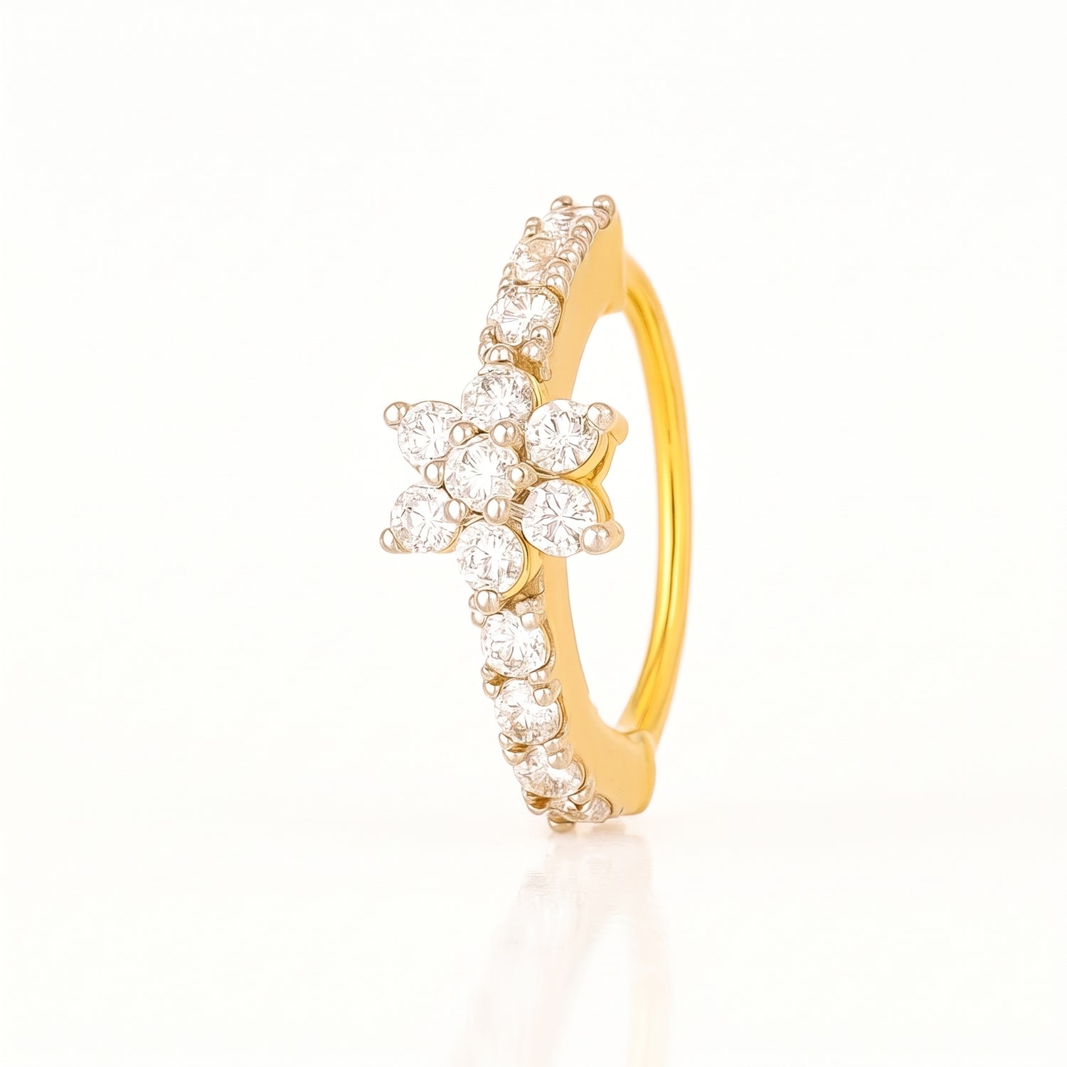 A yellow gold ring featuring a central flower cluster of clear round-cut stones and a curved row of small clear stones along the band, shown on a clean white background.