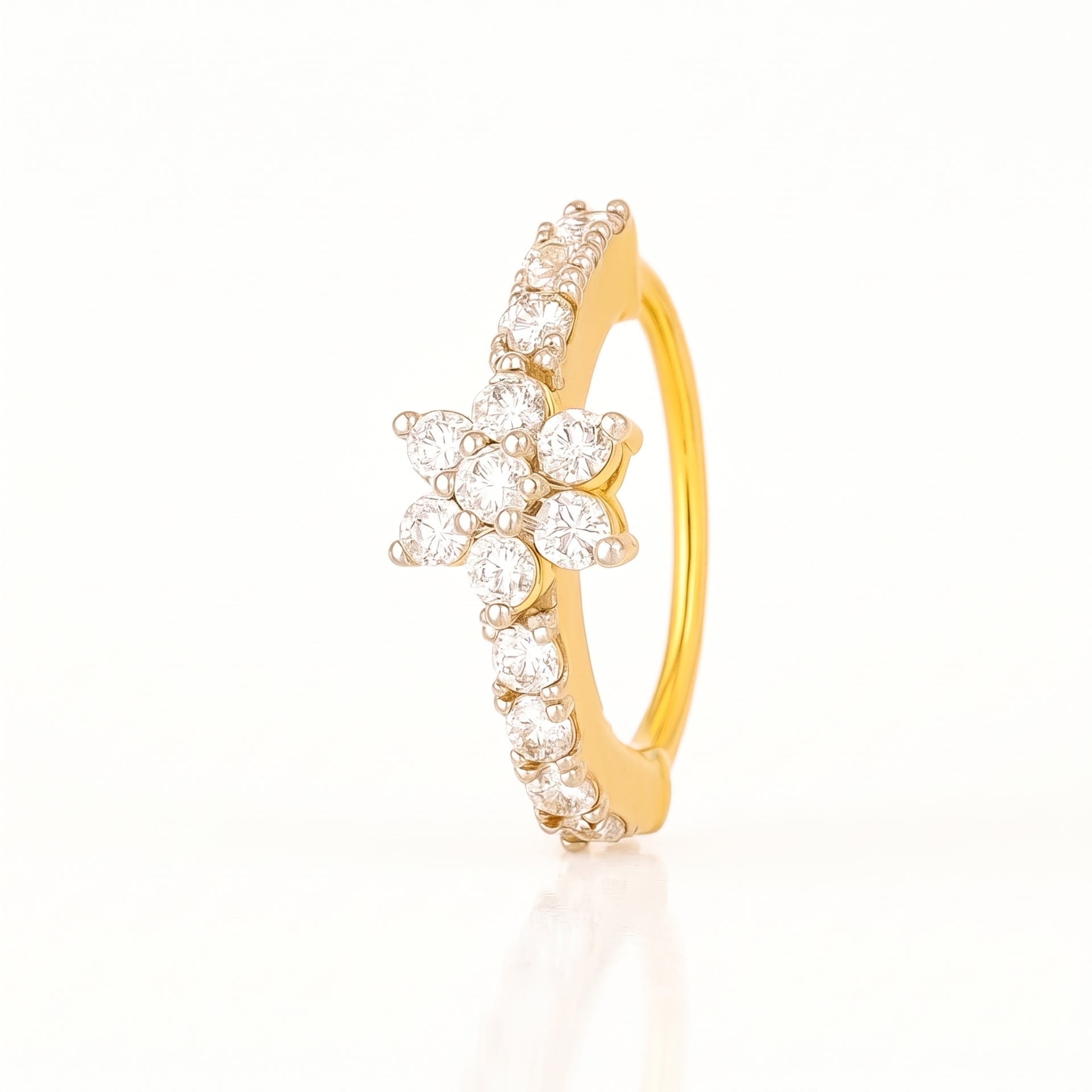 A yellow gold ring featuring a central flower cluster of clear round-cut stones and a curved row of small clear stones along the band, shown on a clean white background.