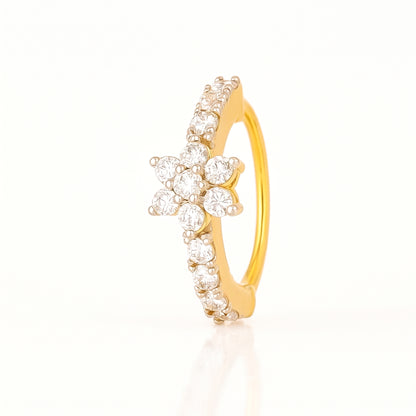 A yellow gold ring featuring a central flower cluster of clear round-cut stones and a curved row of small clear stones along the band, shown on a clean white background.