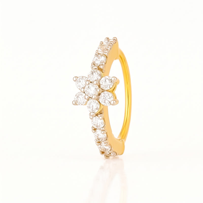 A yellow gold ring featuring a central flower cluster of clear round-cut stones and a curved row of small clear stones along the band, shown on a clean white background.