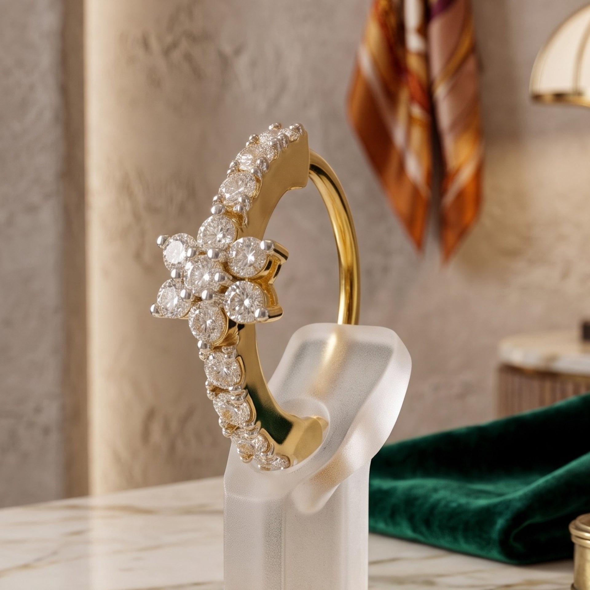 A gold ring with a floral cluster of clear gemstones, displayed on a translucent stand in an elegant indoor setting.
