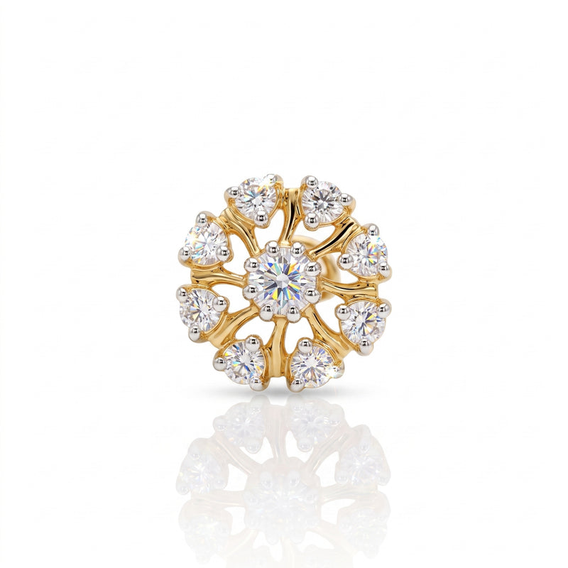 A gold flower-shaped ring with a central round brilliant-cut diamond and surrounding smaller round and heart-shaped diamonds, displayed on a clean white background with a soft reflection below.