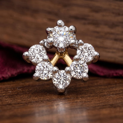 A cluster ring featuring multiple round and marquise-cut clear stones in a silver-toned setting with a gold accent at the center, displayed on a dark wooden surface with a burgundy fabric background.
