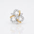 A two-tone yellow gold and white gold flower-shaped ring set with numerous clear round-cut diamonds, photographed on a clean white background with a soft reflection below.
