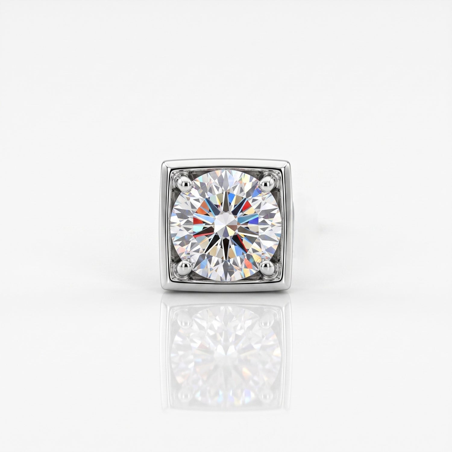 A square-cut diamond solitaire ring in a silver-toned metal setting, centered on a clean white background with a soft reflection below.